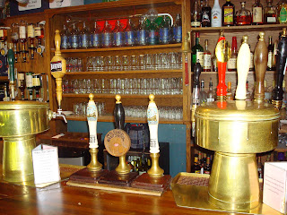 The Ship Inn bar interior with warm candlelight and hand pumps
